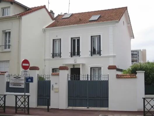 Vue avant restauration d'une maison avec façade écaillée et décolorée.