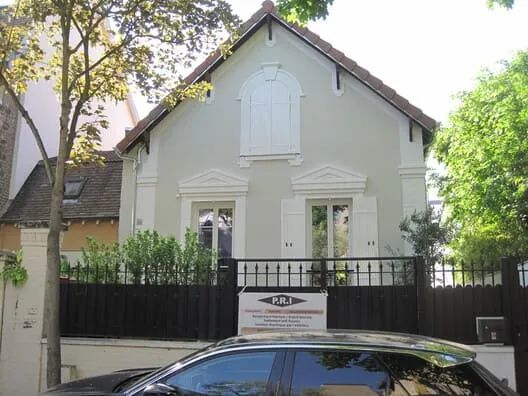 Maison avec façade craquelée et décoloration avant travaux de ravalement.